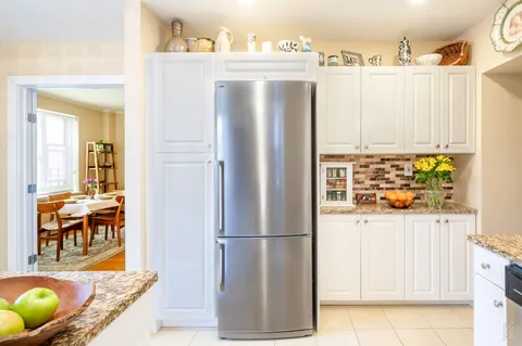 a kitchen with stainless steel appliances a refrigerator and a table
