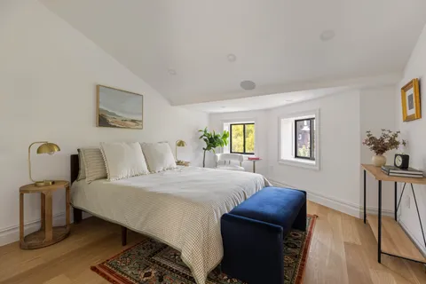 a bedroom with a bed and wooden floor