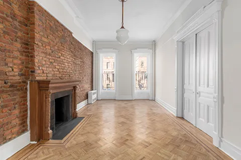a view of an empty room with window and fire place