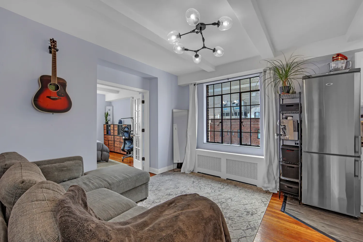 a living room with furniture a chandelier and a window