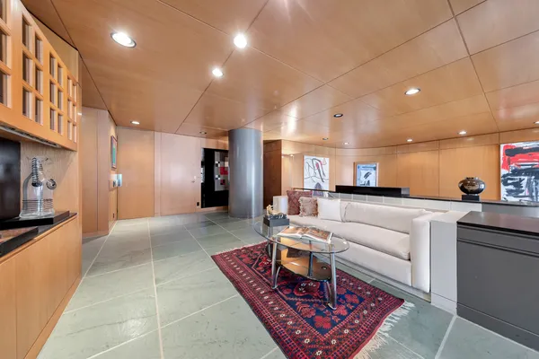 a living room with furniture a red lamp and a refrigerator