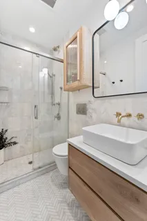 a bathroom with a sink a toilet and shower