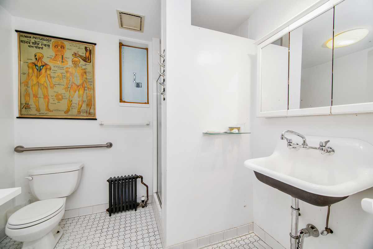 5-38 47th Road Queens, NY 11101 - Photo 11 of 14 a bathroom with a toilet a sink and mirror