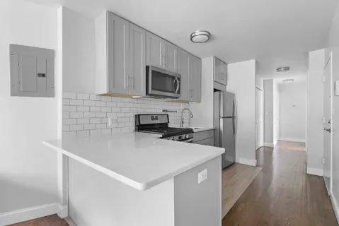 a kitchen with stainless steel appliances a refrigerator a stove a microwave and cabinets