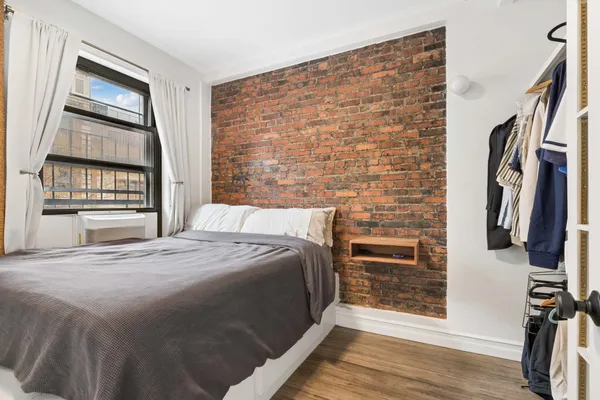 a bed sitting in a bedroom next to a window