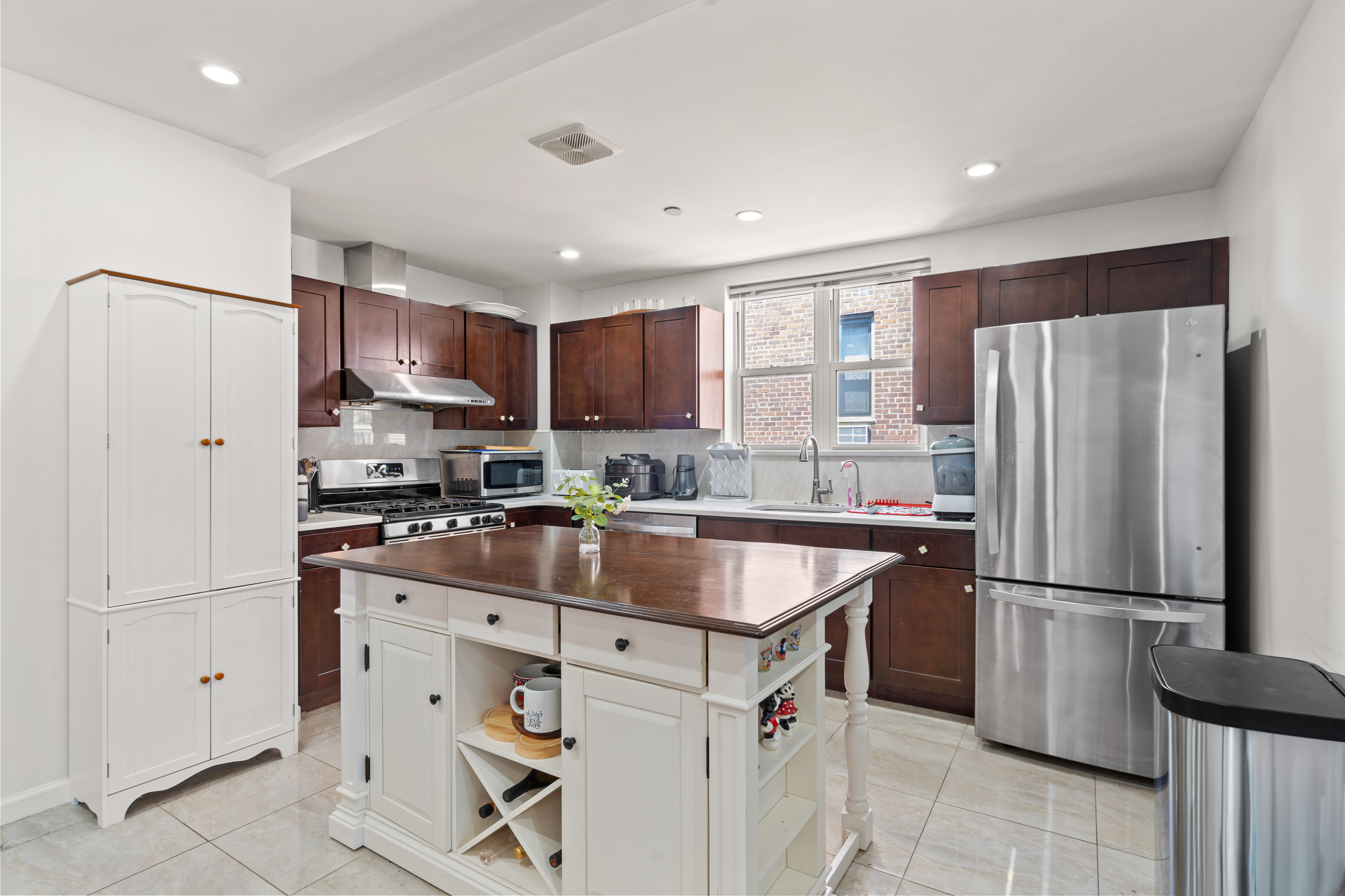 65-33 38th Avenue, Unit 5 Queens, NY 11377 - Photo 5 of 23 a kitchen with stainless steel appliances granite countertop a refrigerator stove a sink and a refrigerator