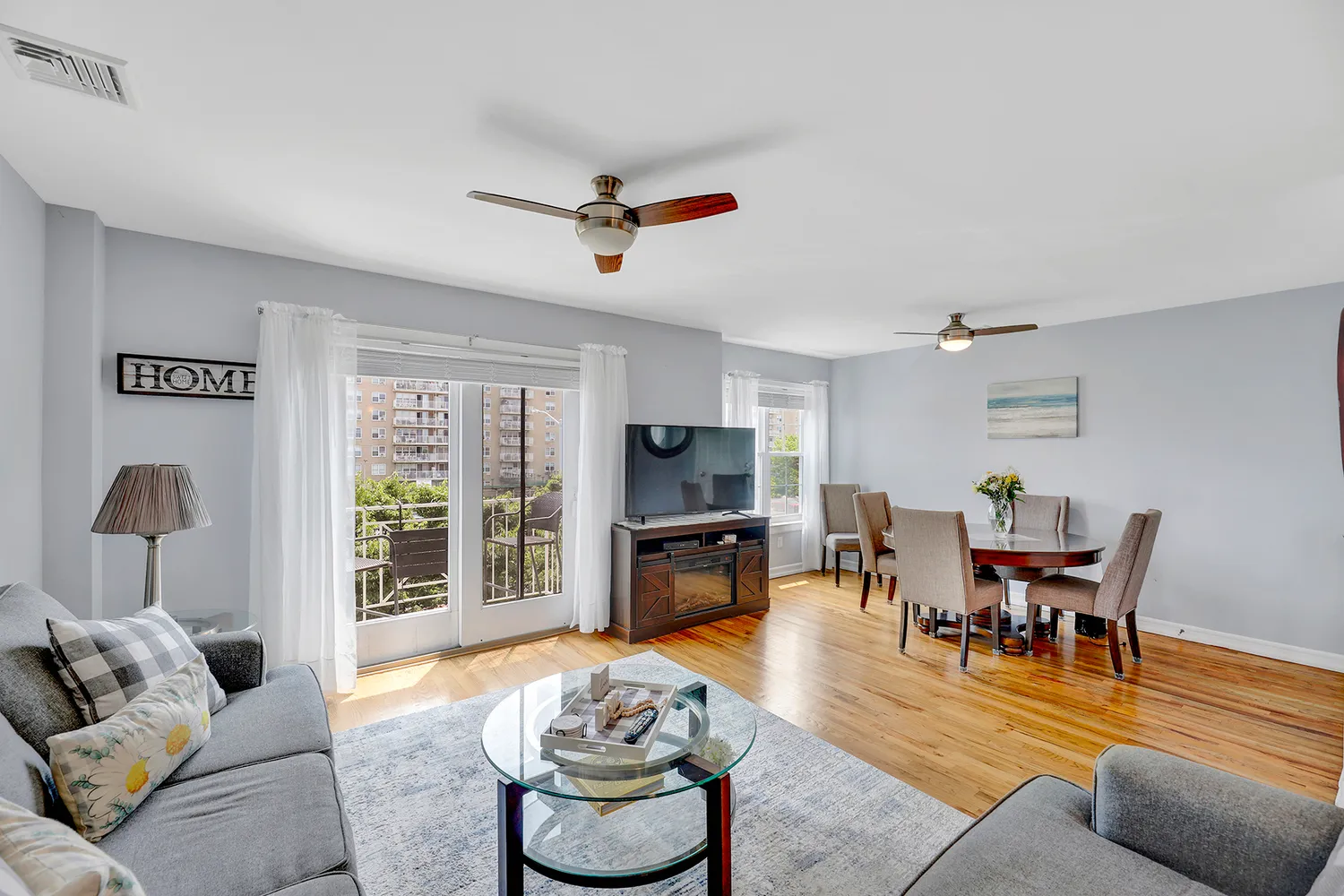a living room with furniture and a flat screen tv with kitchen view