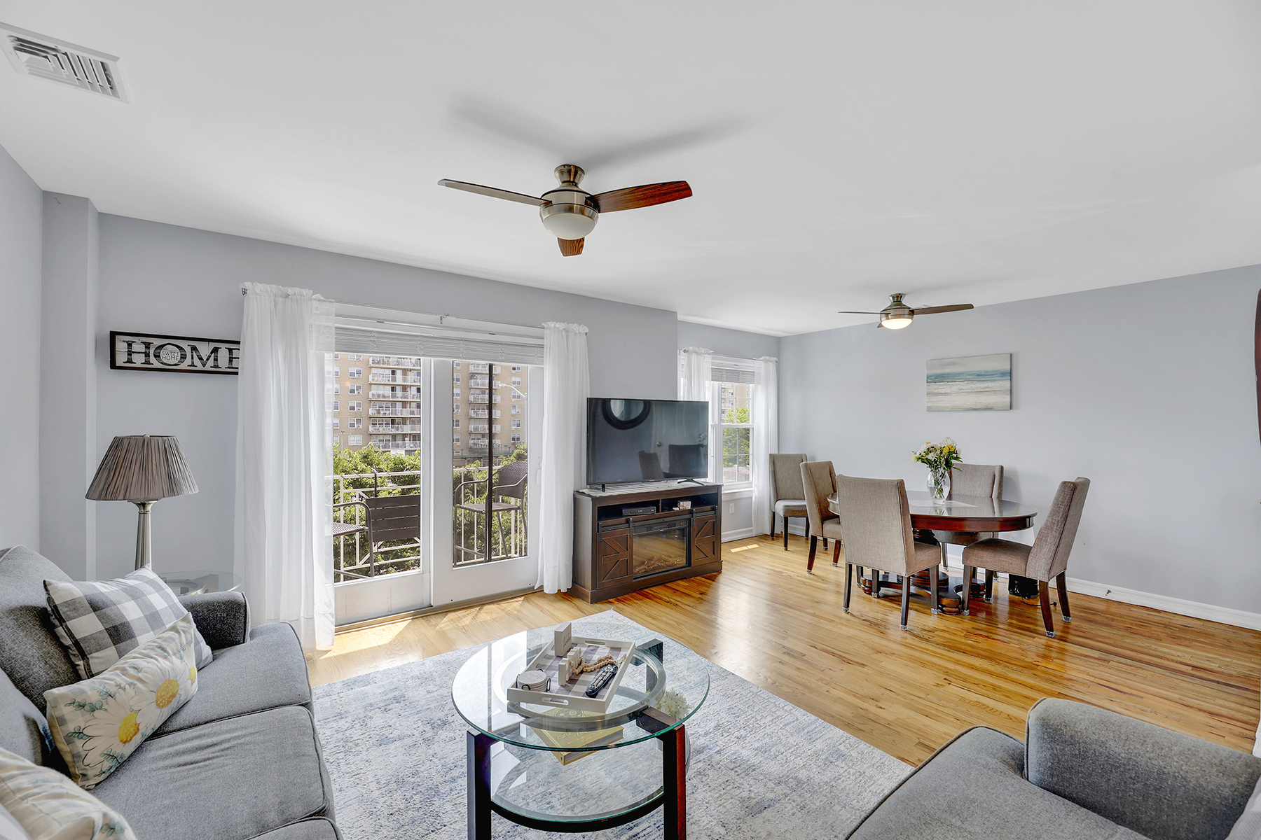 102-20 Rockaway Beach Boulevard, Unit 3C Queens, NY 11694 - Photo 10 of 36 a living room with furniture and a flat screen tv with kitchen view