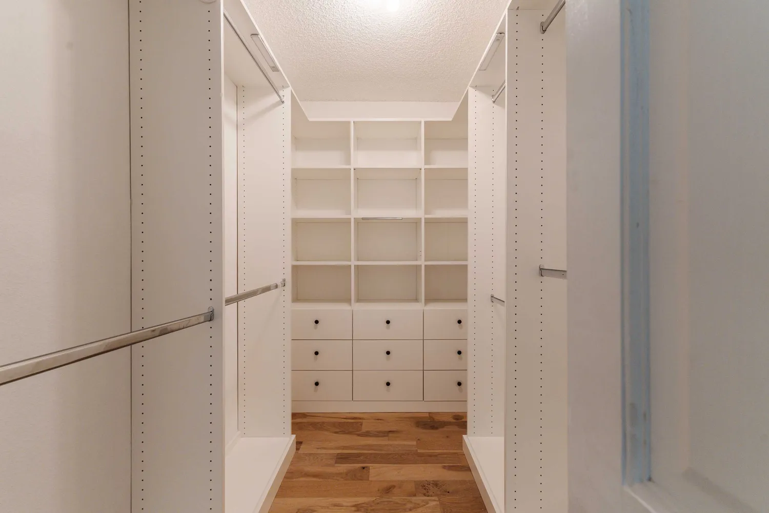 a view of walk in closet with empty racks