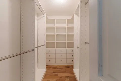 a view of walk in closet with empty racks
