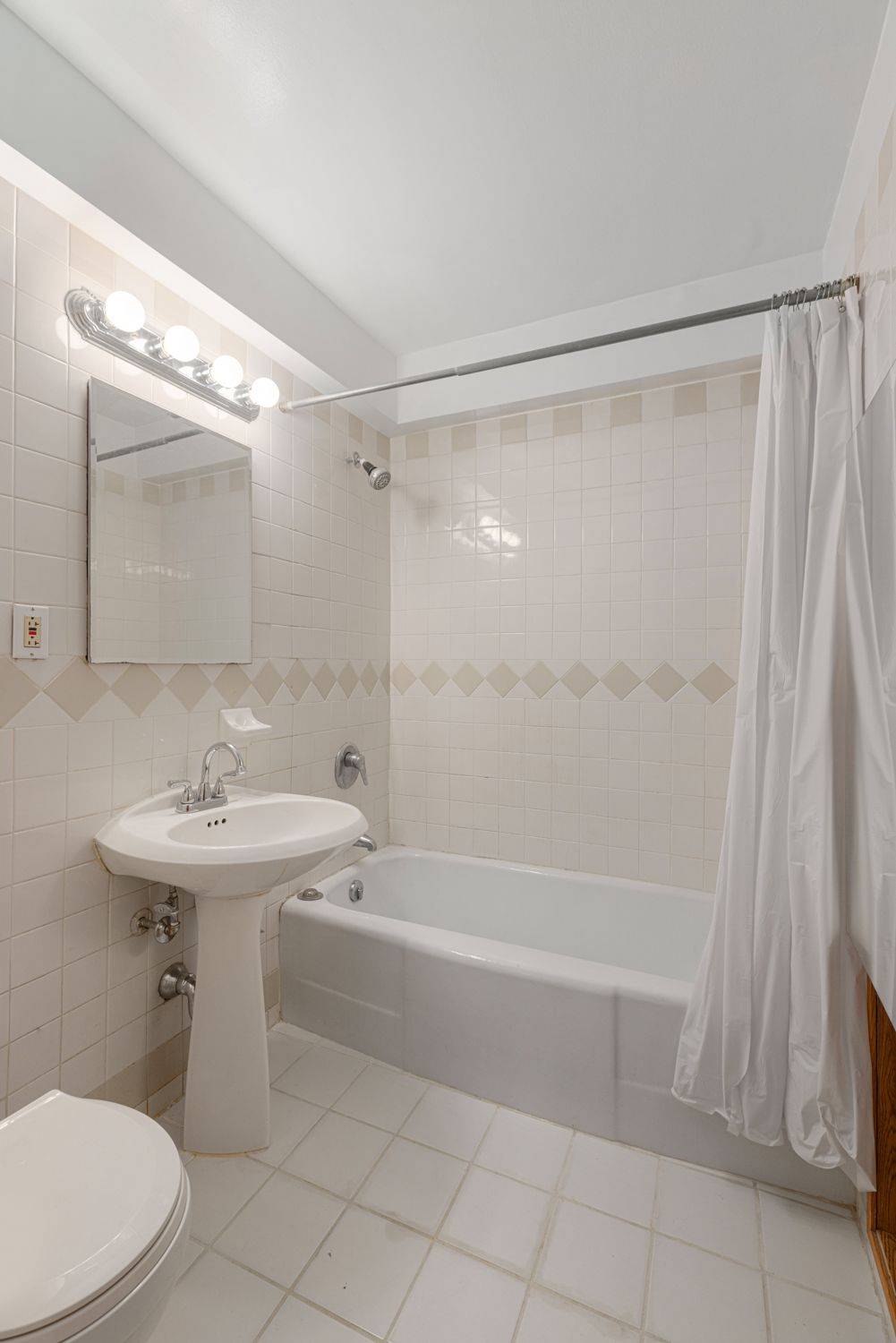 136 East 56th Street, Unit 9J Manhattan, NY 10022 - Photo 13 of 14 a bathroom with a sink a toilet and shower