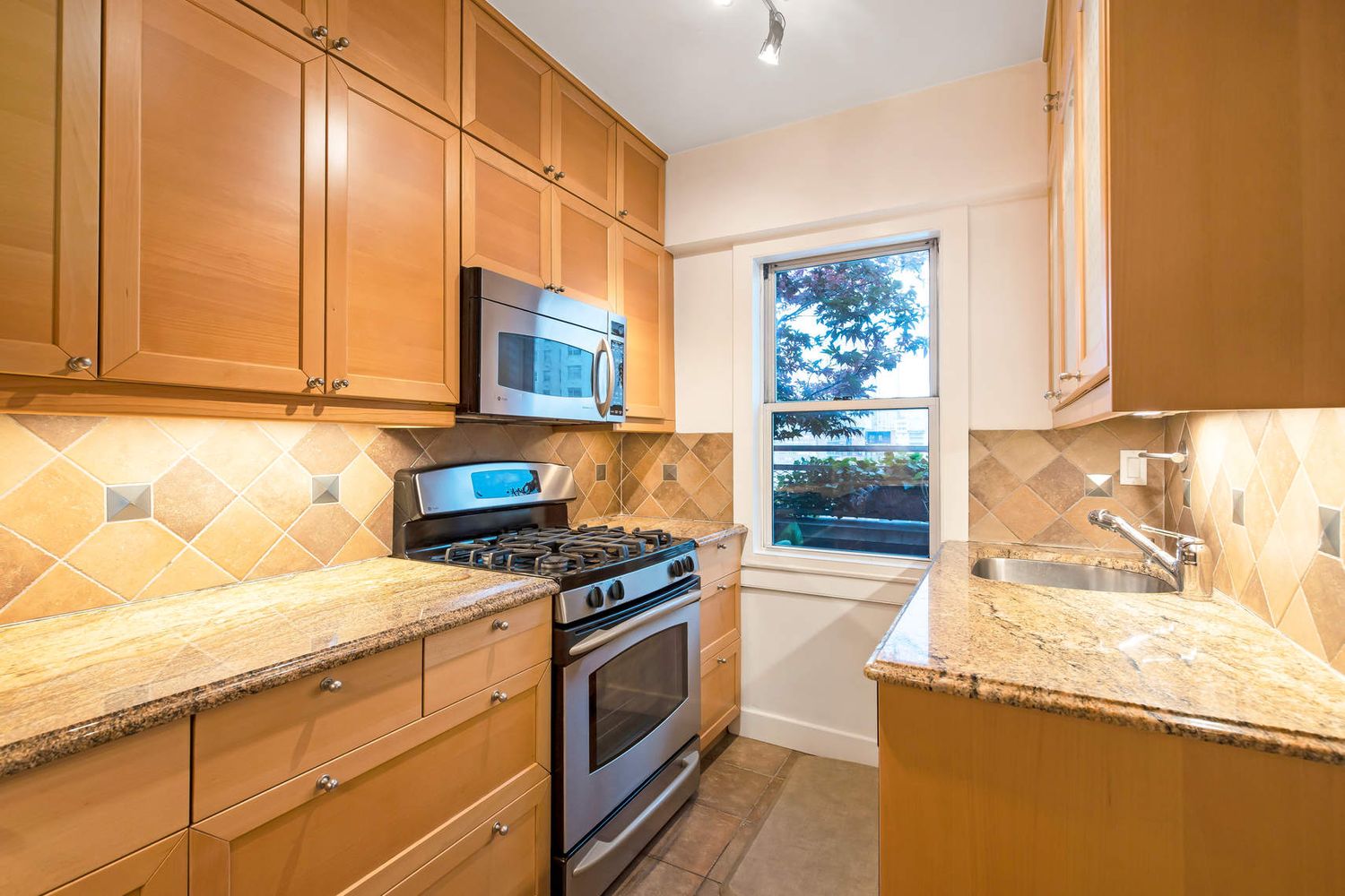 520 East 76th Street, Unit PHC Manhattan, NY 10021 - Photo 8 of 15 a kitchen with granite countertop a stove and a white cabinets
