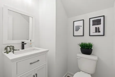 a bathroom with a toilet sink and mirror