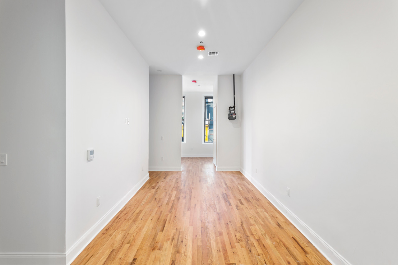281 Grand Street, Unit 2R Manhattan, NY 10002 - Photo 5 of 11 a view of a hallway with wooden floor