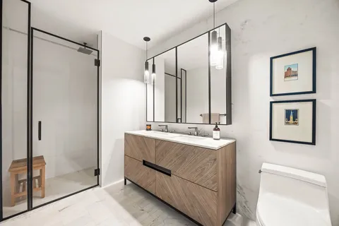 a bathroom with a sink a toilet and shower