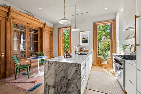 a large kitchen with kitchen island granite countertop a large window in it