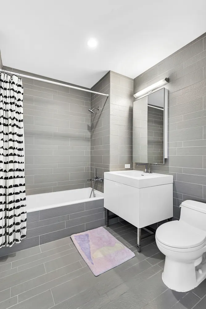 a bathroom with a white tub shower and toilet