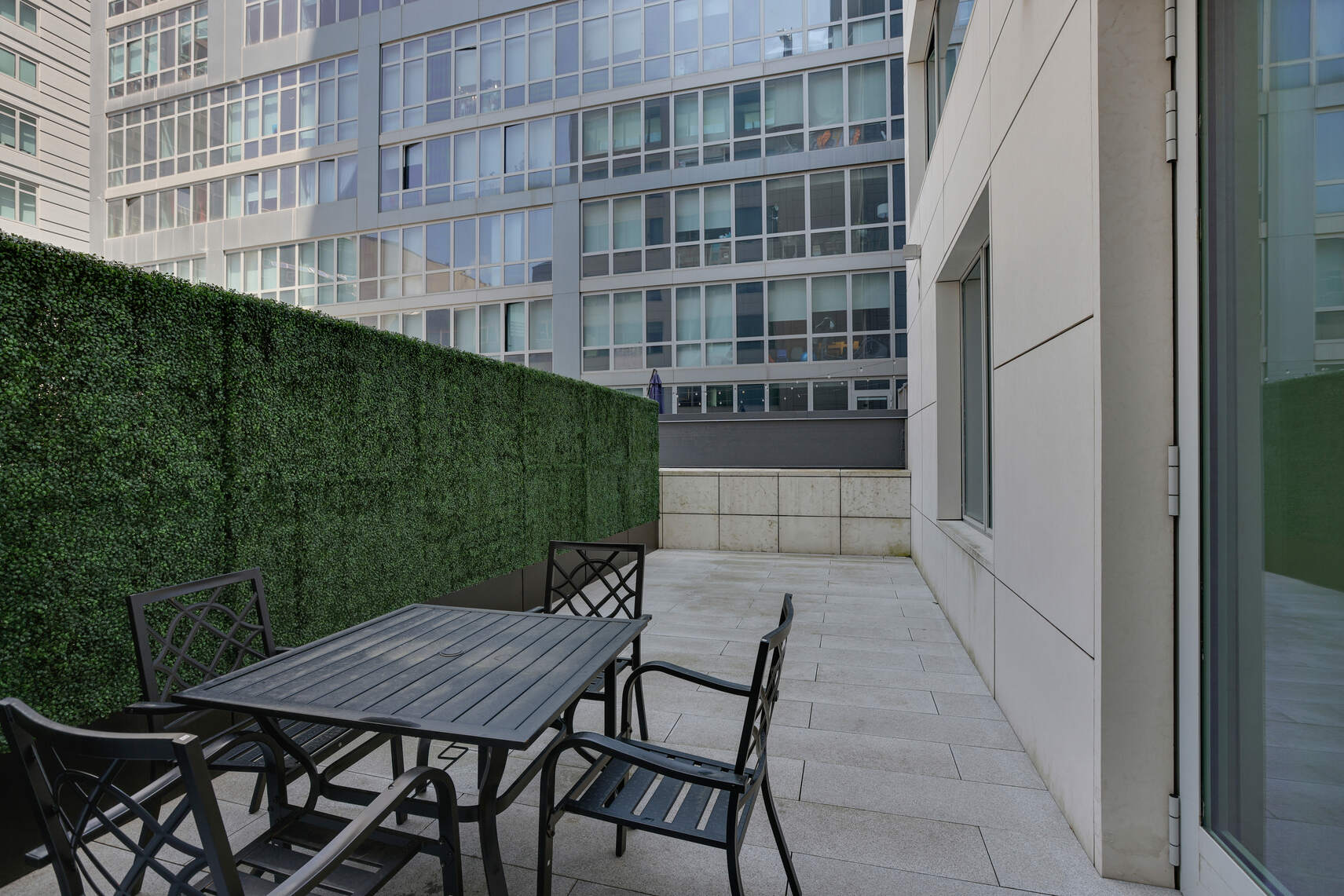 611 West 56th Street, Unit 2D Manhattan, NY 10019 - Photo 6 of 10 a backyard of a house with barbeque oven and outdoor seating