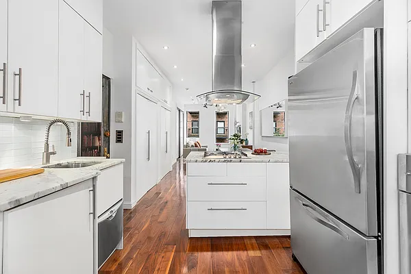13 Downing Street, Unit 8 Manhattan, NY 10014 - Photo 6 of 10 a kitchen with stainless steel appliances a refrigerator sink and cabinets
