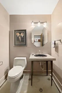 a bathroom with a toilet a sink and mirror