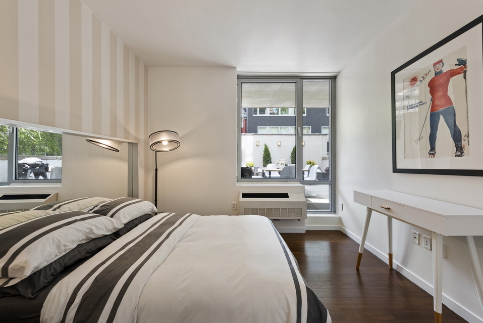 444 West 19th Street, Unit 201 Manhattan, NY 10011 - Photo 9 of 13 a bedroom with a bed and a large window with outer view