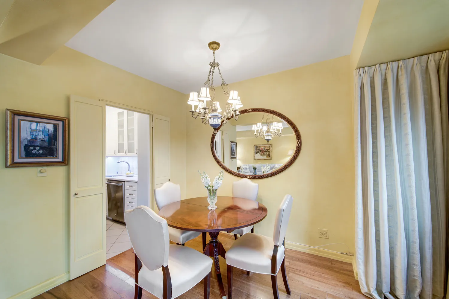 a dining room with chandelier and wooden floor