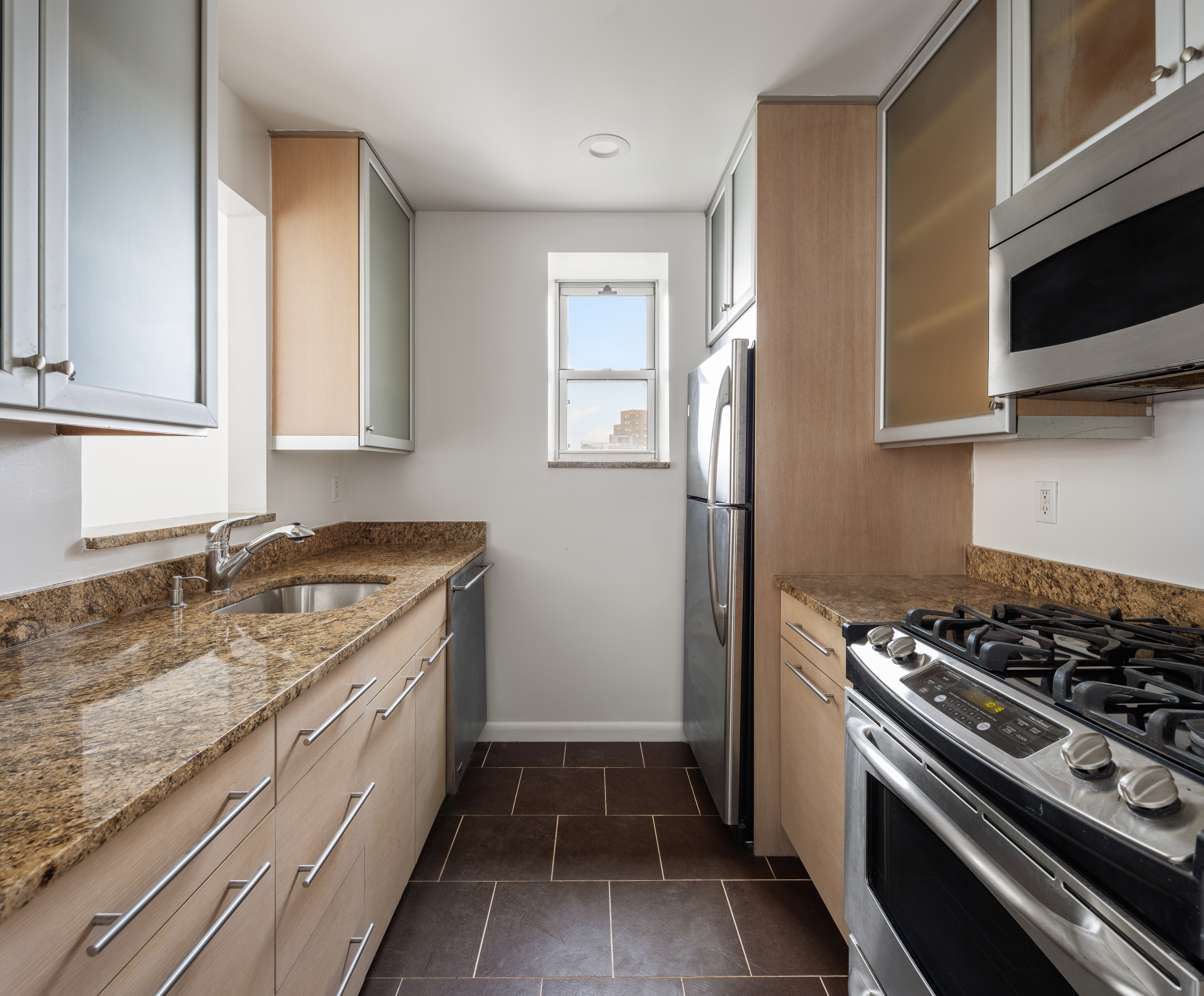 a kitchen with granite countertop stainless steel appliances a stove a sink and a microwave