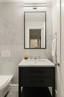a bathroom with a toilet sink and mirror