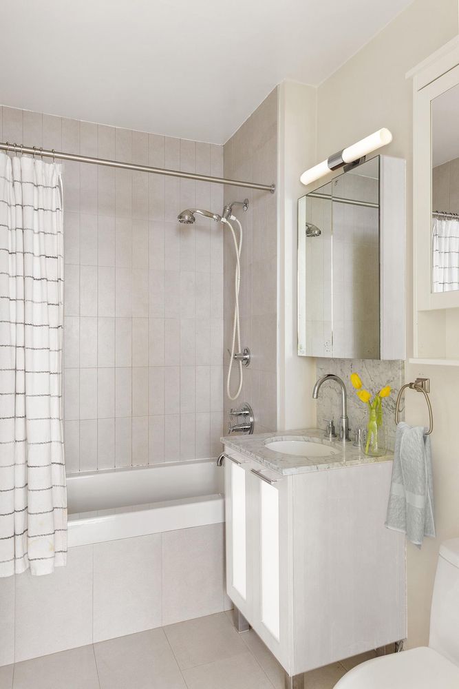a bathroom with a granite countertop sink mirror and a bathtub