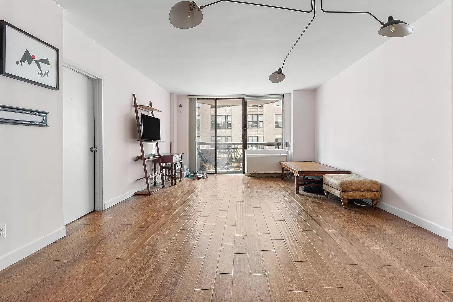 108 5th Avenue, Unit 15C Manhattan, NY 10011 - Photo 2 of 12 a living room with furniture and a flat screen tv