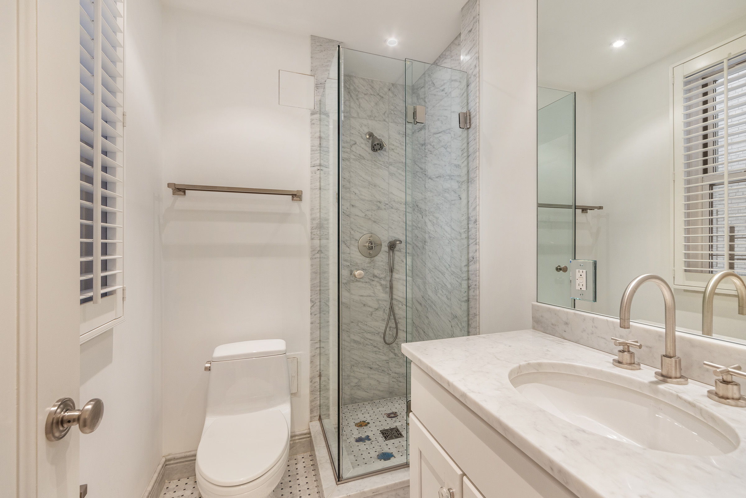 25 East 86th Street, Unit 3C Manhattan, NY 10028 - Photo 9 of 15 a bathroom with a shower sink vanity mirror and toilet