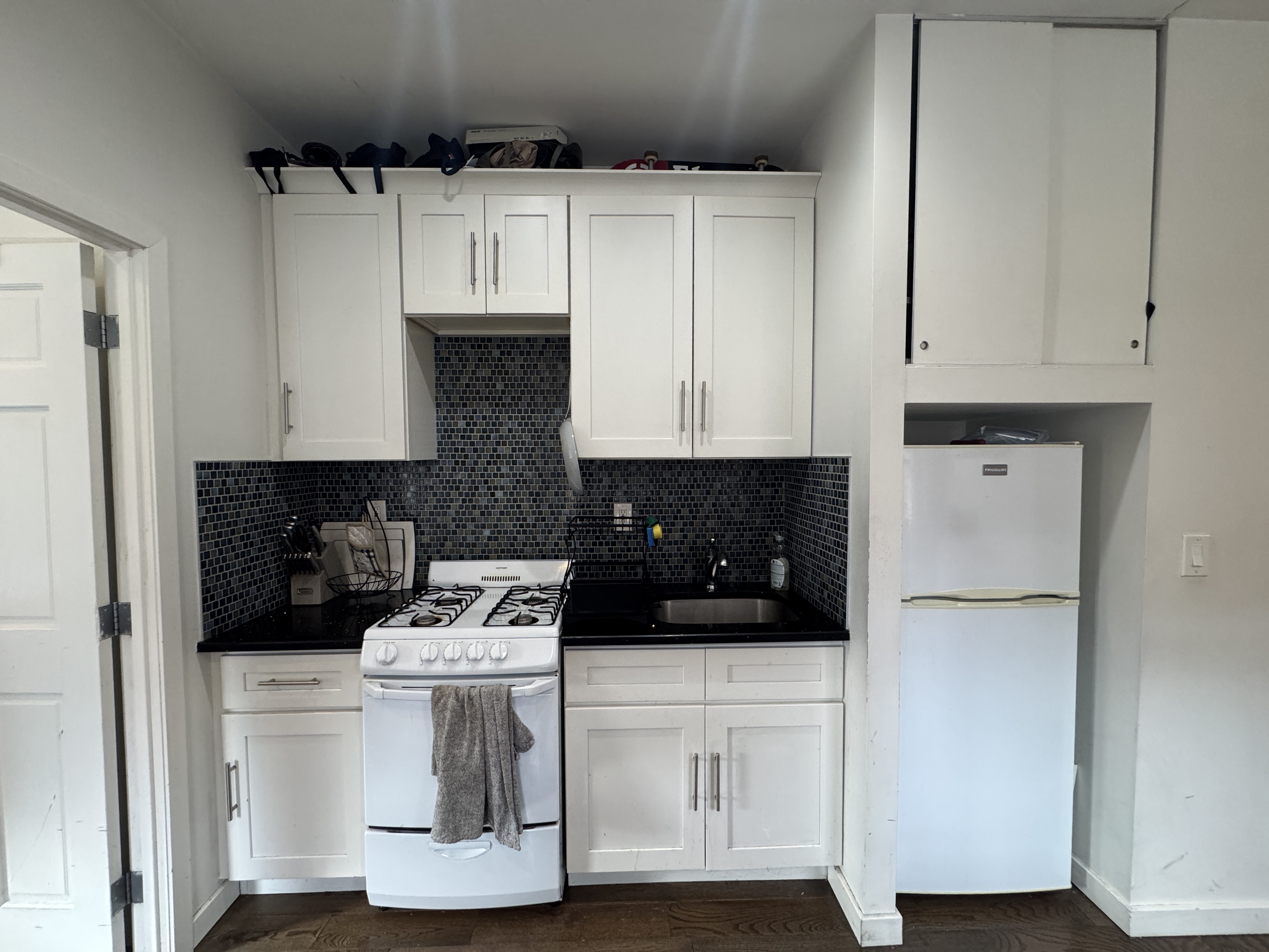 108 Stanton Street, Unit 1A Manhattan, NY 10002 - Photo 8 of 11 a kitchen with a refrigerator and white cabinets