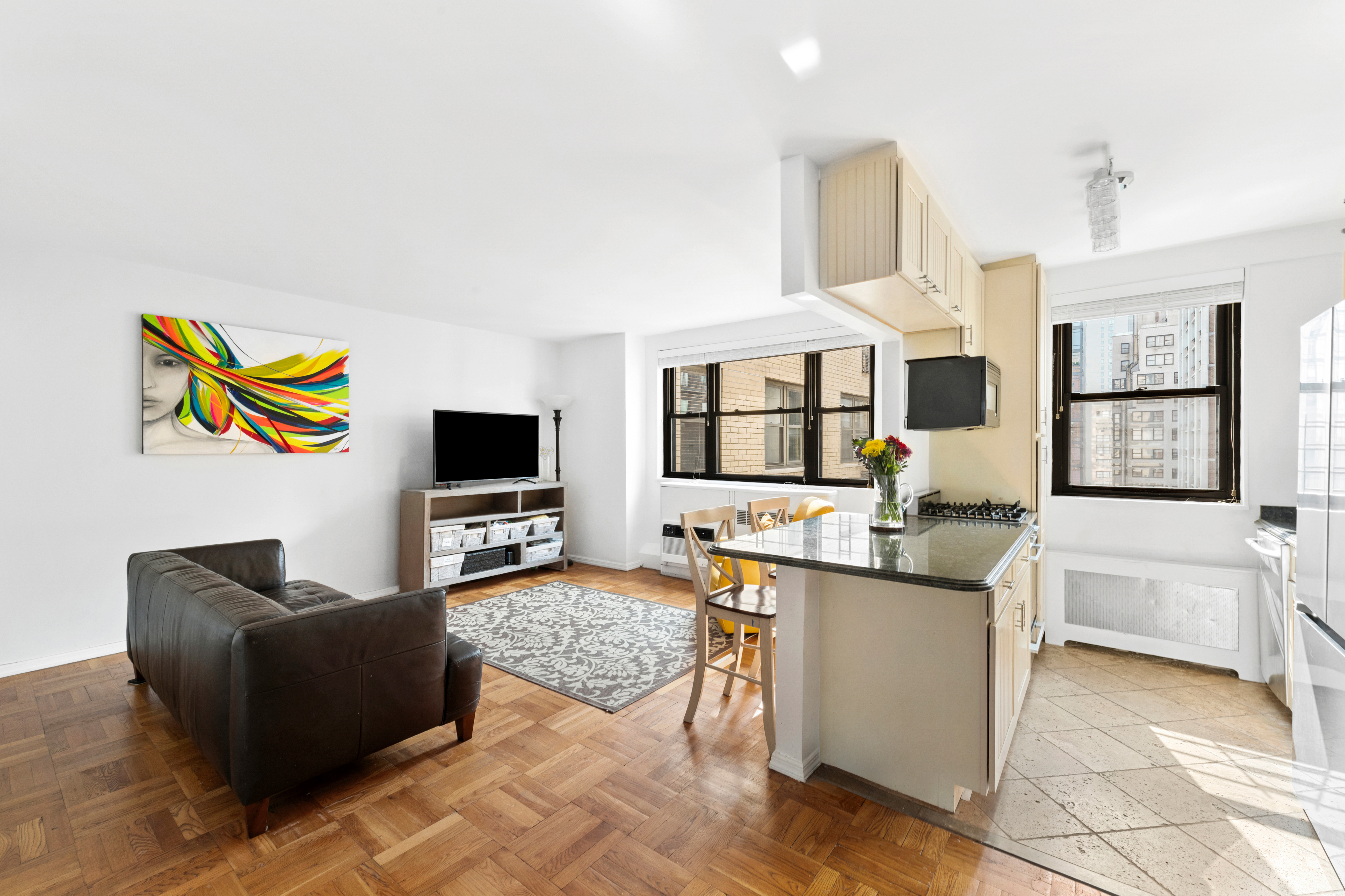 315 East 72nd Street, Unit 15M Manhattan, NY 10021 - Photo 4 of 18 a living room with furniture and flat screen tv