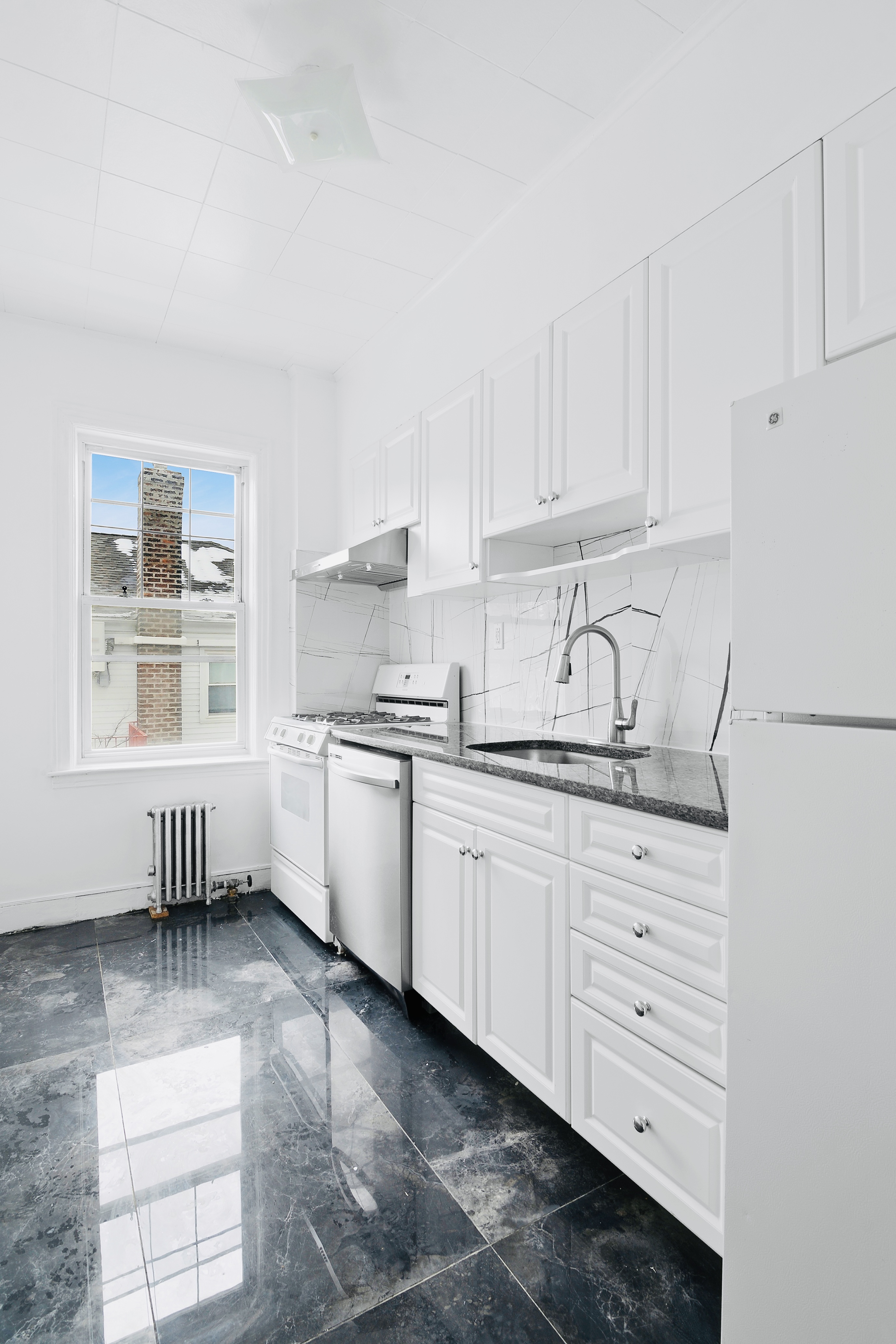 63-33 Haring Street, Unit 2F Queens, NY 11374 - Photo 3 of 7 a kitchen with granite countertop white cabinets and white appliances