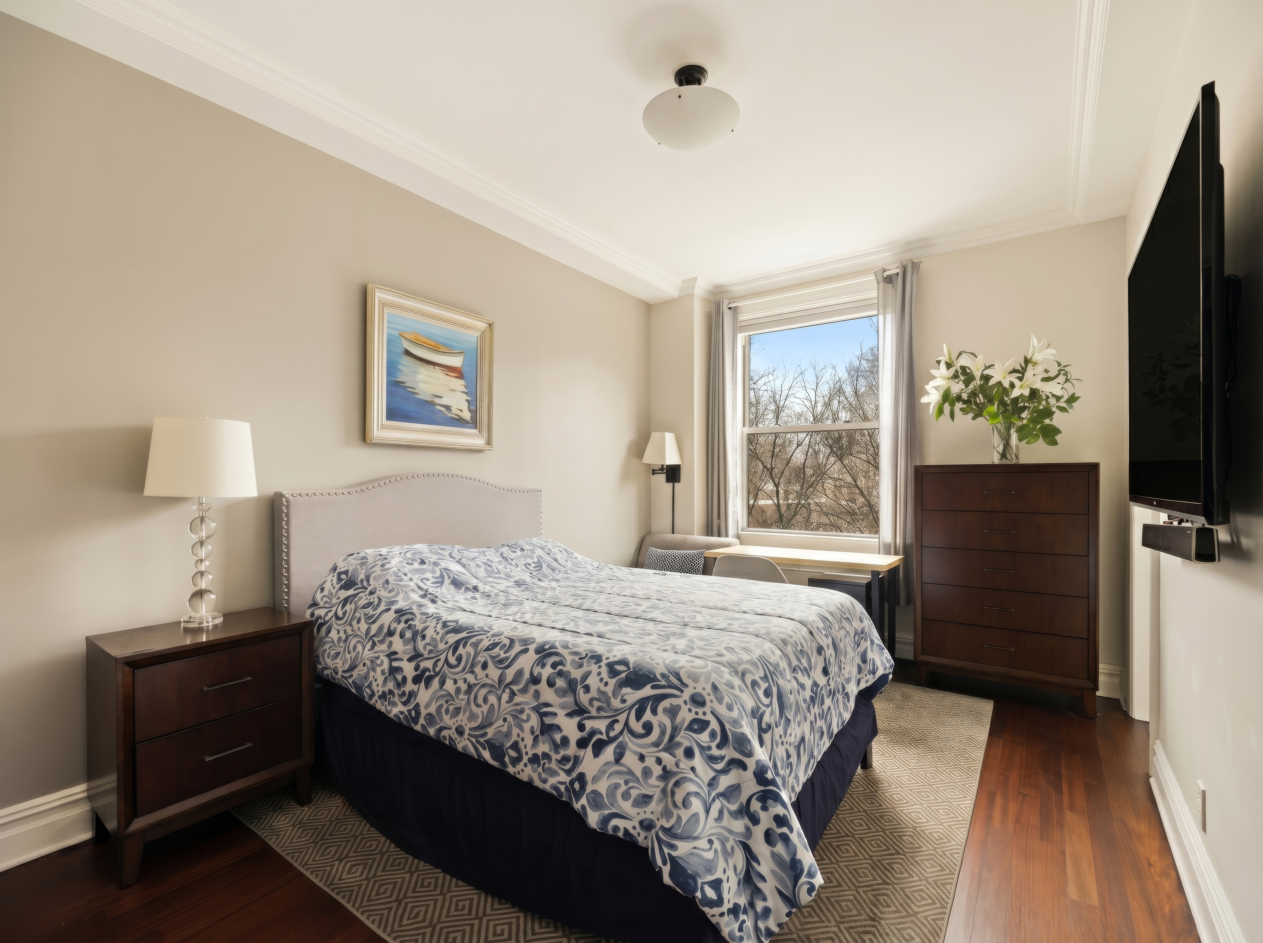 1158 5th Avenue, Unit 4A Manhattan, NY 10128 - Photo 13 of 24 a bedroom with a bed and a flat tv screen on a dresser