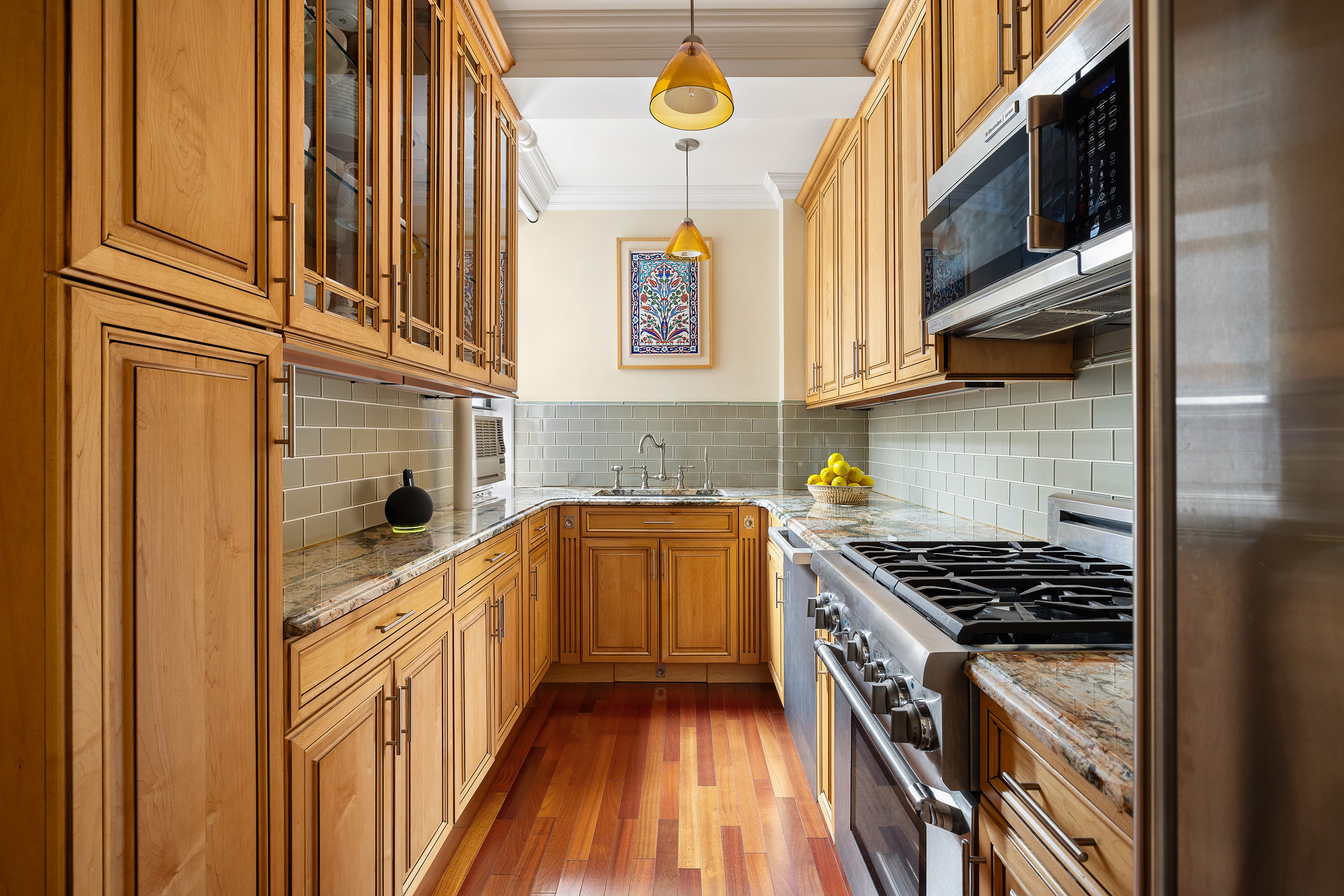 119 East 84th Street, Unit 9C Manhattan, NY 10028 - Photo 4 of 10 a kitchen with stainless steel appliances granite countertop a stove and a refrigerator