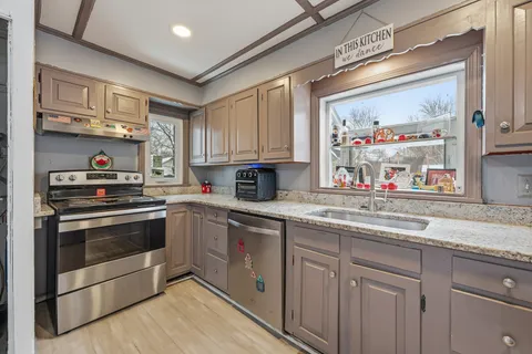 a kitchen with stainless steel appliances granite countertop a stove and a sink