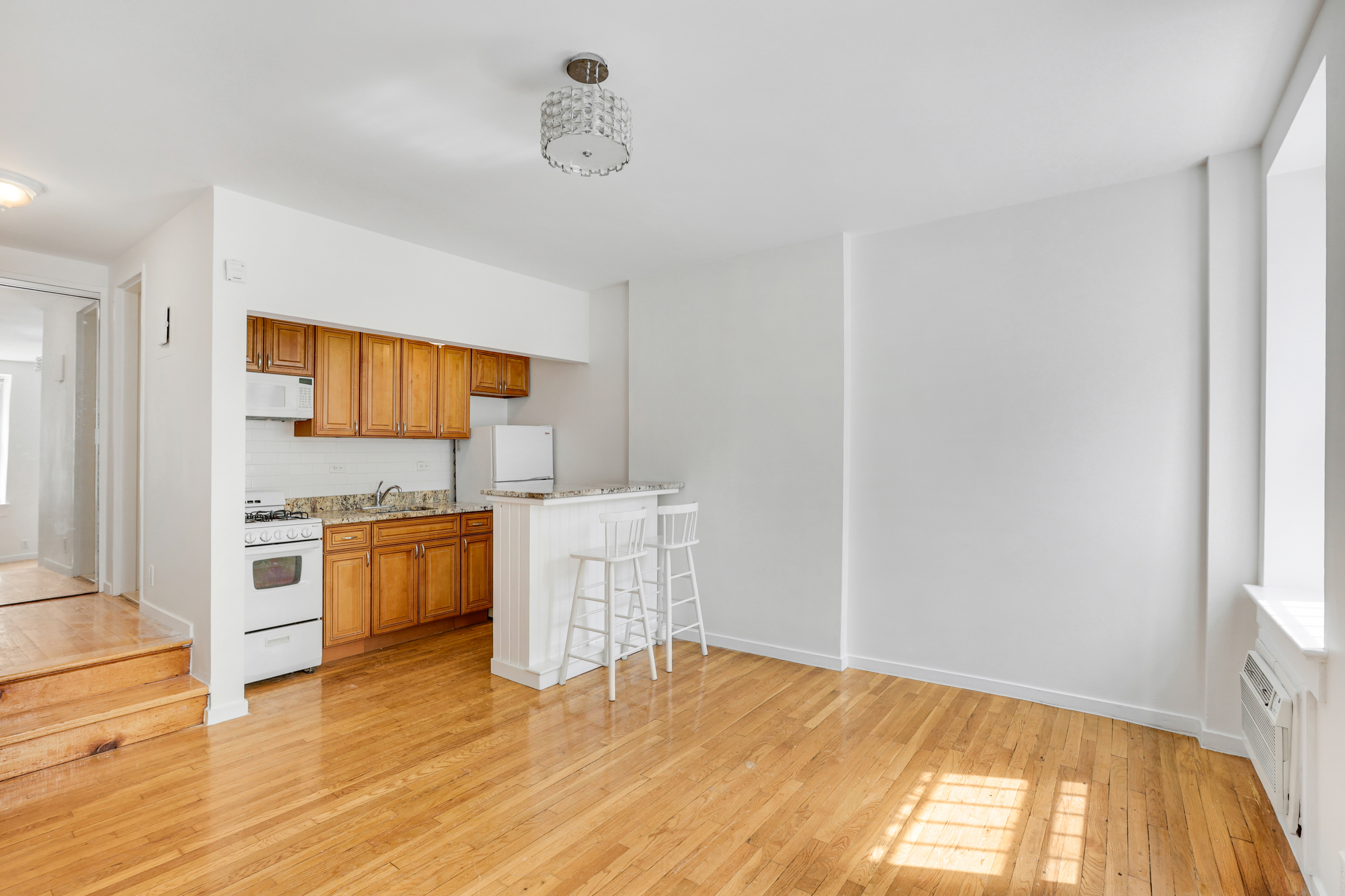 141 West 94th Street, Unit 1F Manhattan, NY 10025 - Photo 2 of 9 a kitchen with granite countertop a stove a sink and a refrigerator
