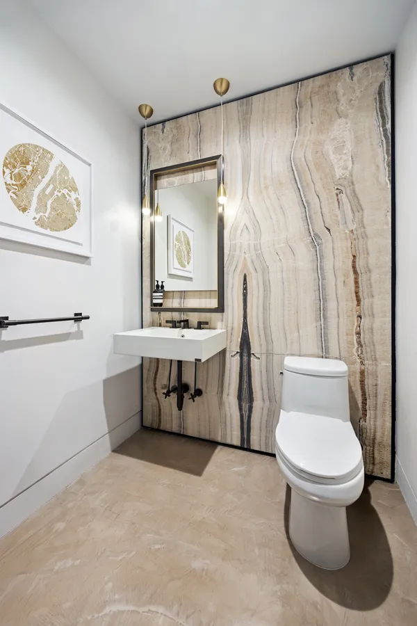 a white toilet sitting next to a bathroom sink