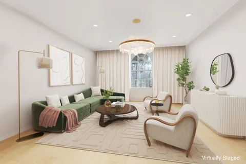 a living room with furniture a large window and a potted plant