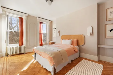 a bedroom with a bed and wooden floor
