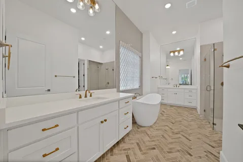 a spacious bathroom with a double vanity sink toilet mirror and bathtub