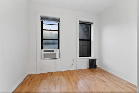 an empty room with windows and closet