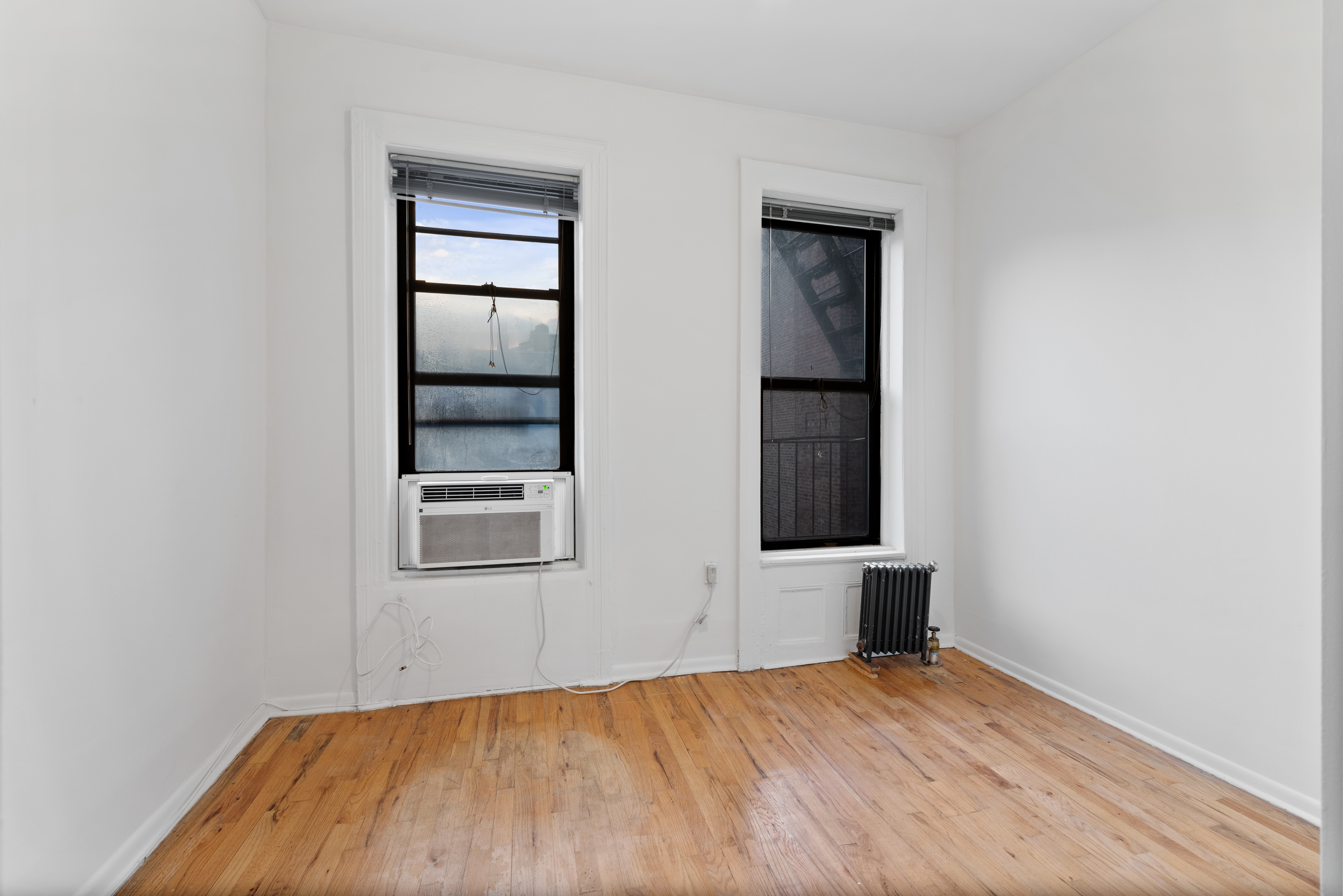 142 Sullivan Street, Unit 18 Manhattan, NY 10012 - Photo 6 of 11 an empty room with windows and closet