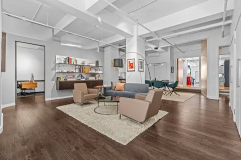 a living room with furniture and a dining table with wooden floor