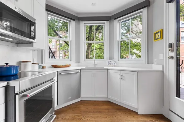 a kitchen with a sink cabinets stainless steel appliances and a window
