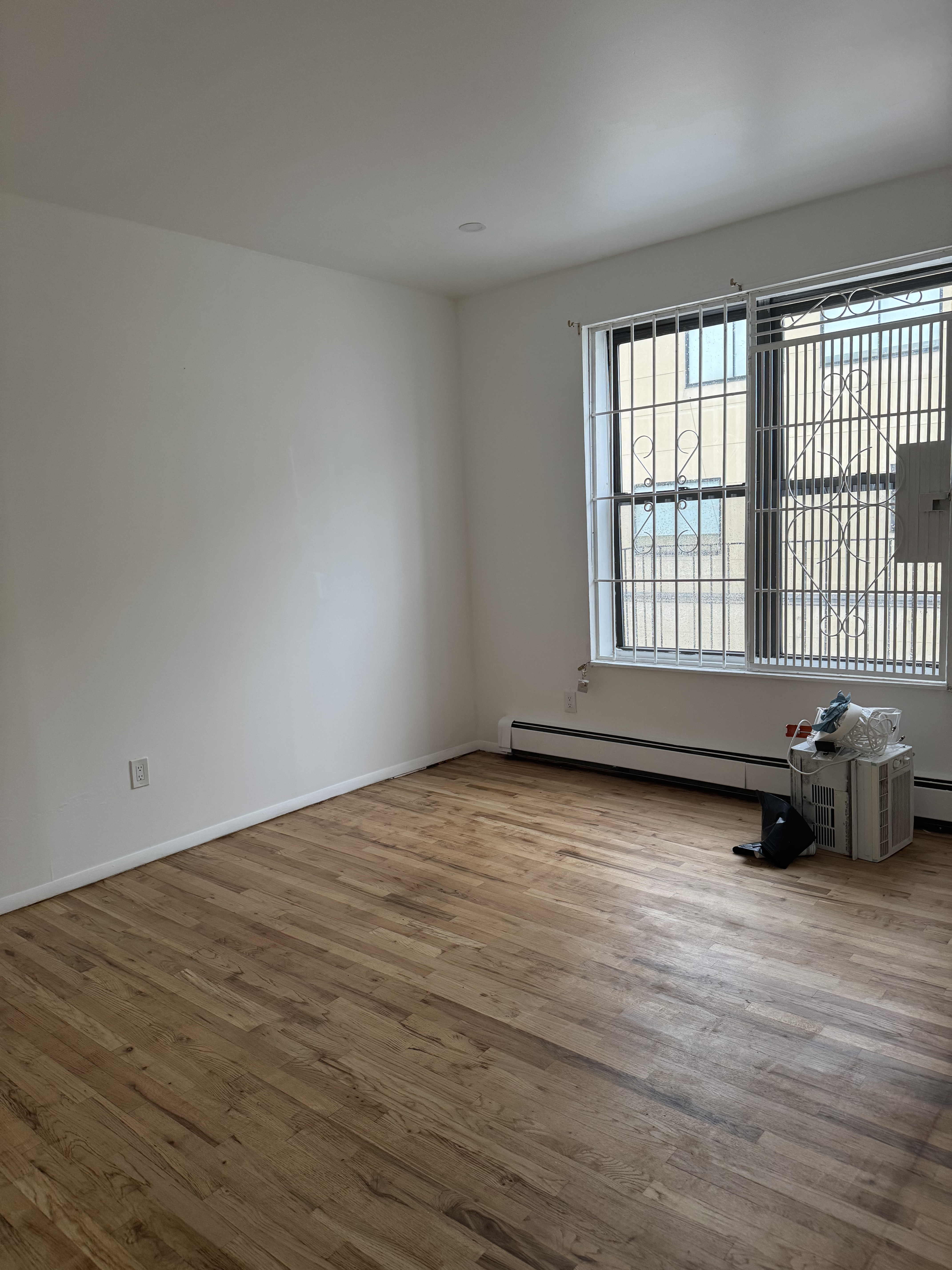 149 Sterling Street, Unit 4D Brooklyn, NY 11225 - Photo 3 of 7 a view of an empty room with wooden floor and a window