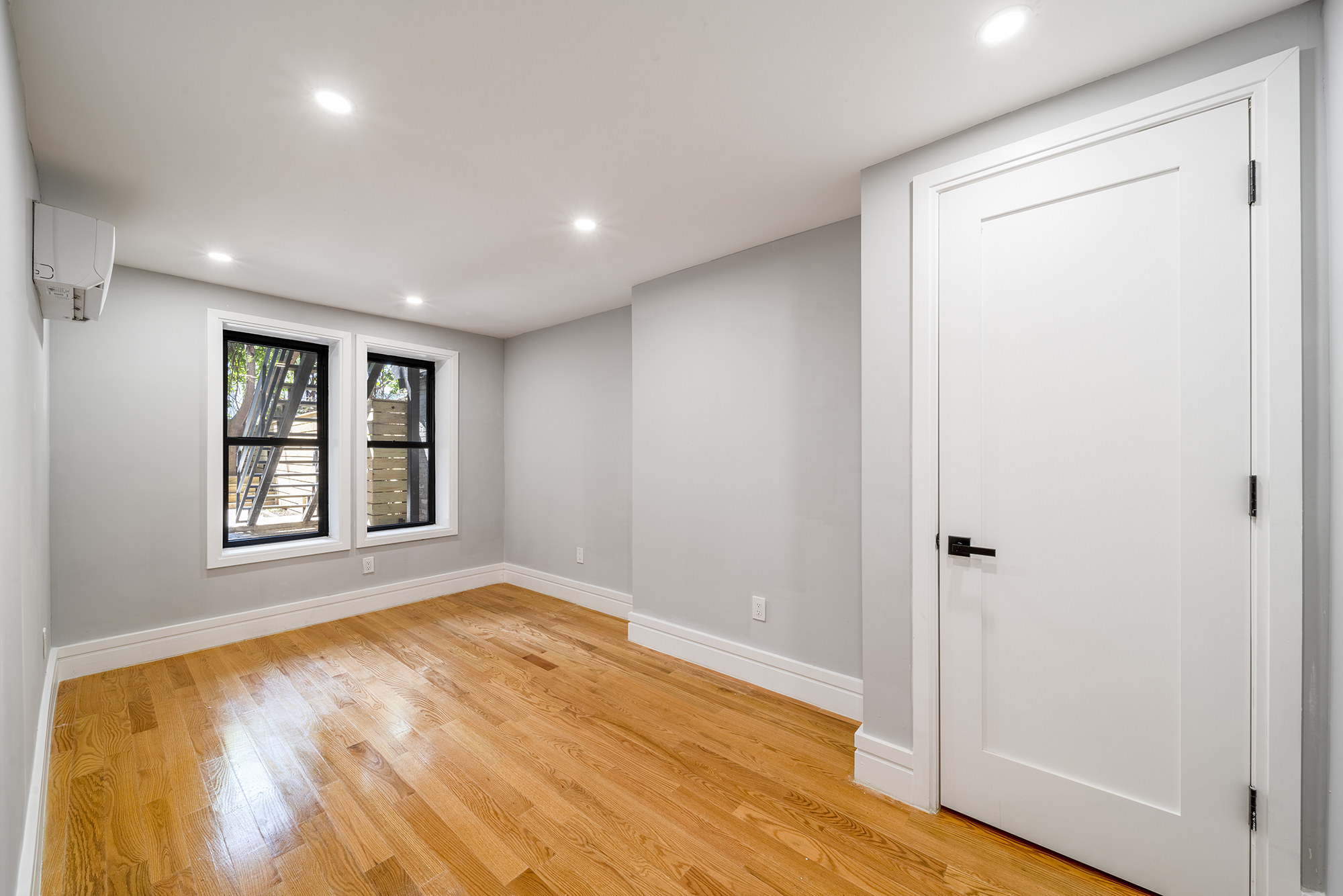 192 Weirfield Street, Unit ONE Brooklyn, NY 11221 - Photo 6 of 8 a view of an empty room with wooden floor and a window