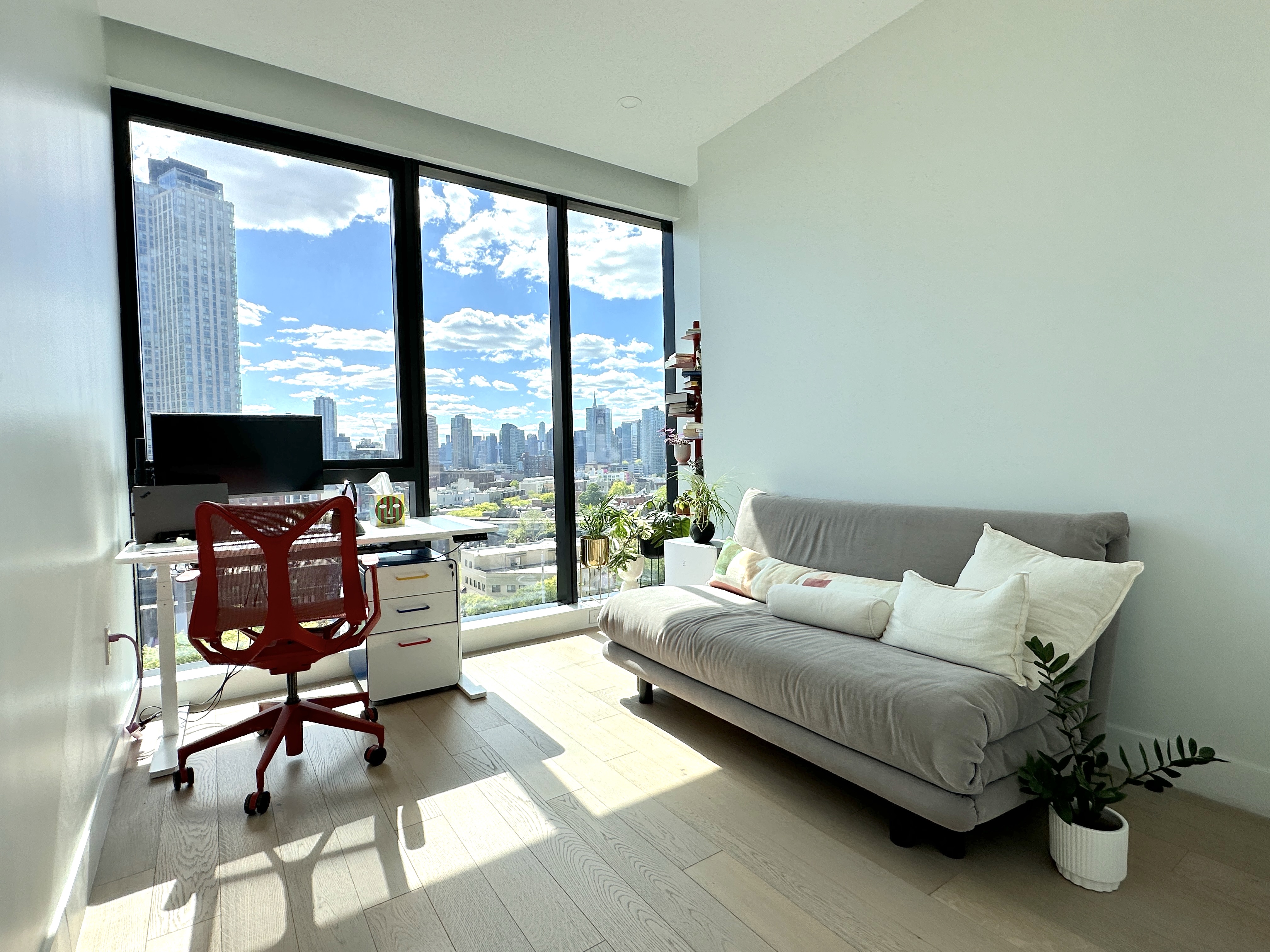 4507 Court Square West, Unit 10E Queens, NY 11101 - Photo 7 of 14 a living room with furniture and a floor to ceiling window