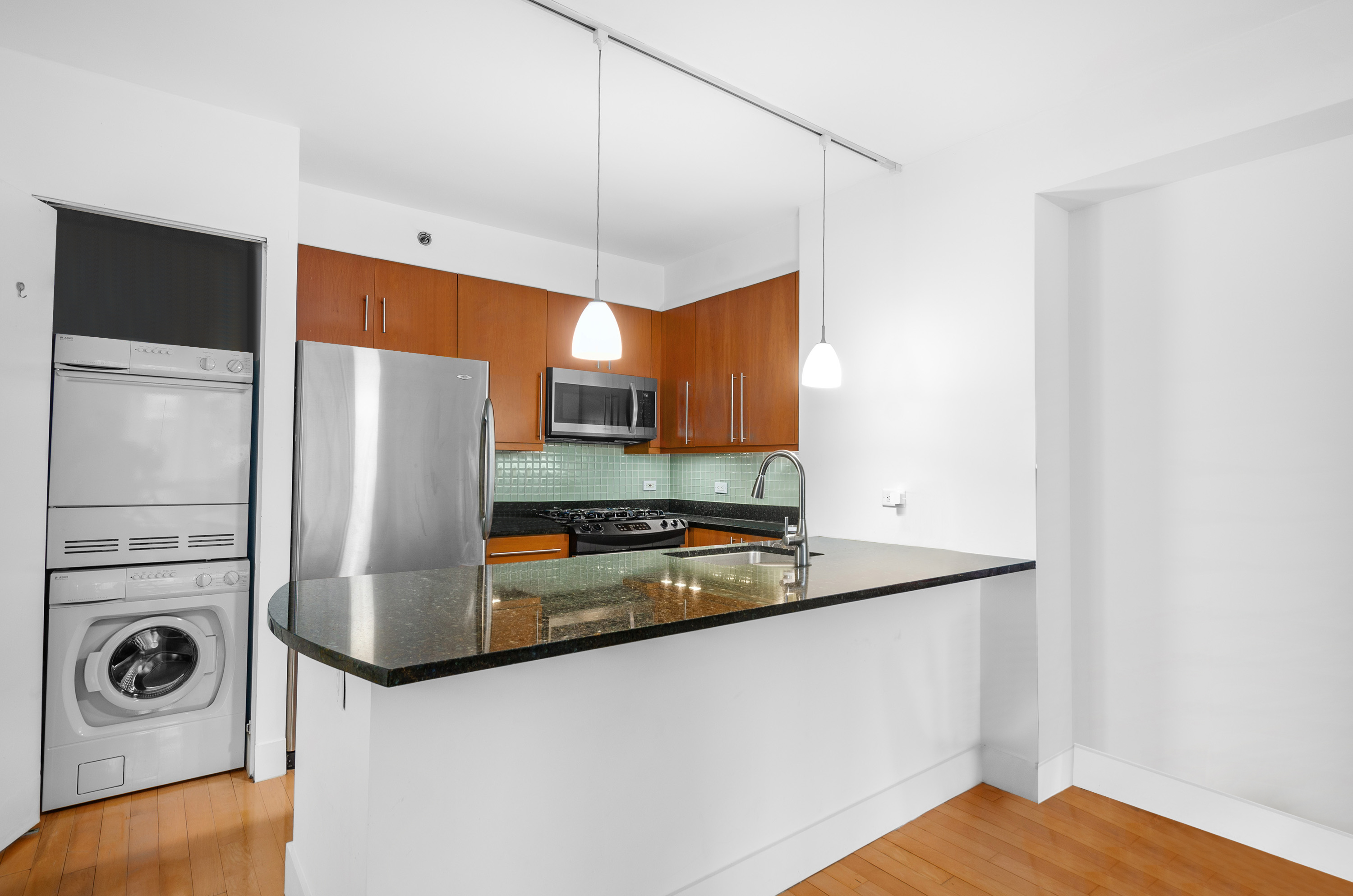 242 East 25th Street, Unit 5B Manhattan, NY 10010 - Photo 9 of 12 a kitchen with stainless steel appliances granite countertop a refrigerator a stove and a sink with wooden floor
